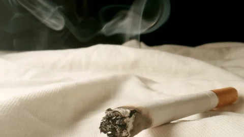 MACRO: Cigarette smoking on a bed at home - Dolly shot Видео 202066086