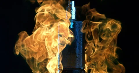 Macro of classy perfume vial bottle in blazing orange explosion fire flames Stock Footage 268413372