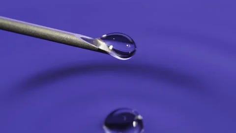 Macro Clear fluid dripping out of a Syringe needle. Biotech, Vaccine, CRISPR Stock-Footage 133624759