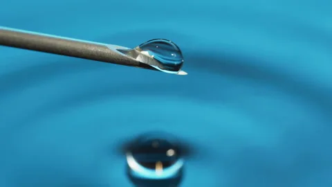Macro Clear fluid dripping out of a Syringe needle. Biotech, Vaccine, CRISPR Video stock 133625600