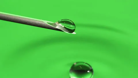 Macro Clear fluid dripping out of a Syringe needle. Biotech, Vaccine, CRISPR Stock Footage 133625666