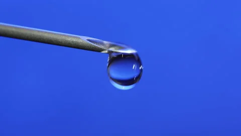 Macro Clear fluid dripping out of a Syringe needle. Biotech, Vaccine, CRISPR Stock-Footage 133625933