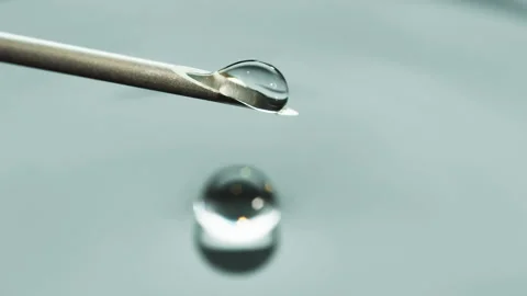 Macro Clear fluid dripping out of a Syringe needle. Biotech, Vaccine, CRISPR Video stock 133626089