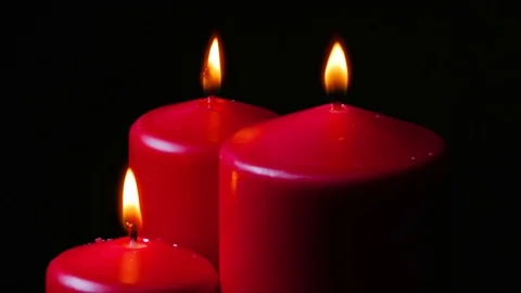 Macro close up up 3 lit red candles rotating around black background 2 Stock Footage 70244308