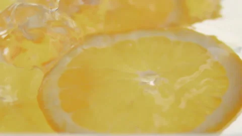 Macro close up of 3 slices of Orange  splashing in water in slow motion Video stock 273121825
