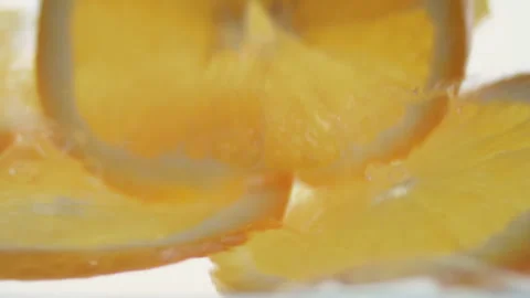 Macro close up of 3 slices of Orange  splashing in water in slow motion Stock Footage 273121827
