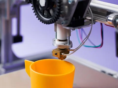 Macro Close-up of 3D Printer Nozzle Extruding Plastic Cup 스톡 사진