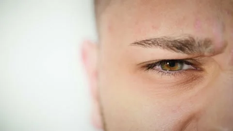 Macro close up of angry man's face with beautiful blue and brown hazel eye. Stock Footage 167524961