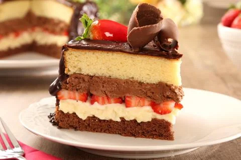 Macro close up of appetizing slice of dark chocolate cake and strawberry with Stock Photos