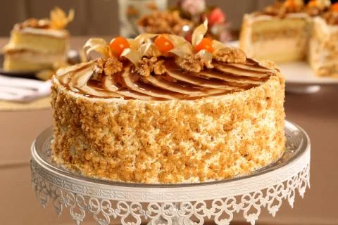 Macro close up of appetizing white chocolate cake with walnuts and Physalis w Stock Photos