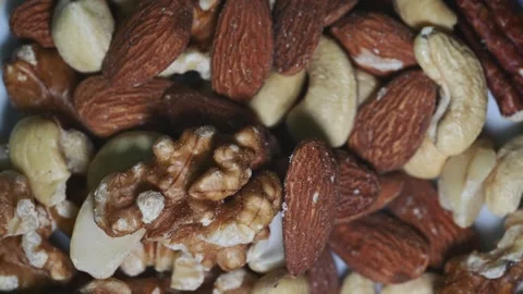Macro Close Up of Assorted Nuts Rotating Under Changing Light Stock Footage 344954402