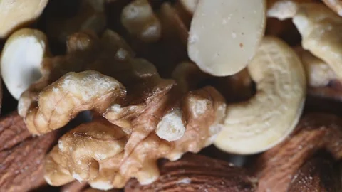 Macro Close Up of Assorted Nuts Rotating Under Changing Light Stock Footage 344954444