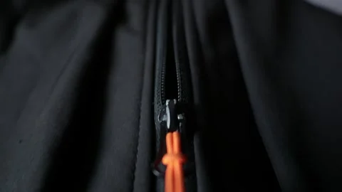 Macro Close Up of Black Jacket Zipper with Bright Orange Pull Cord Video stock 338093817