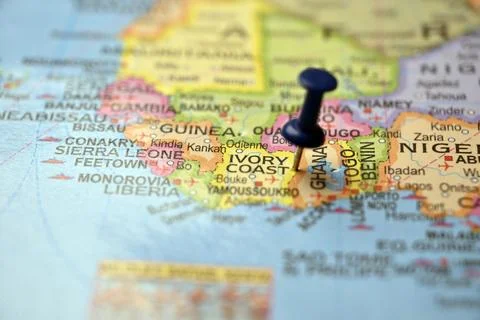 Macro Close-Up Blue Push Pin Highlighting Ivory Coast on Blurred World Map .. Stock Photos