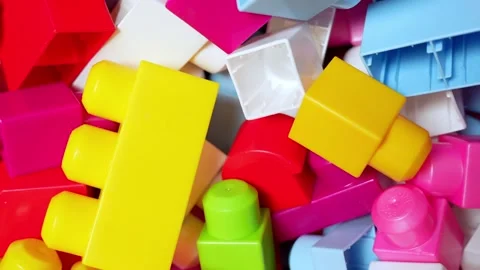 Macro close-up of bright interlocking plastic building blocks in a messy pile Stock Footage 325842895