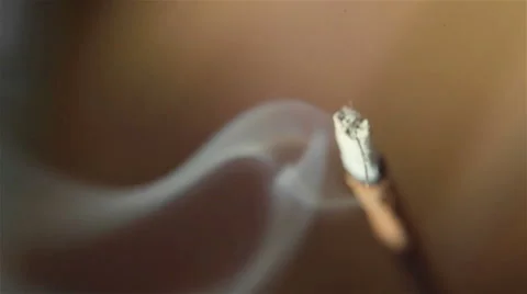 Macro close up of burning incense sticks with smoke over brown background Stock Footage 49775433
