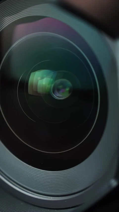 Macro close-up of a camera lens rotating as the focus ring turns, with colorful Видео 331322458