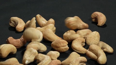 Macro Close-up of Cashew Nuts Falling in Slow Motion on Black. Video stock 332838823