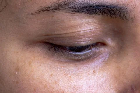 Macro close-up of a closed human eye highlighting natural skin texture Stock Photos