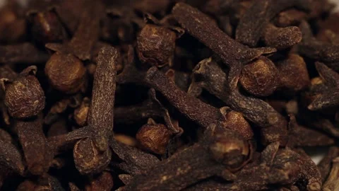 Macro close up of cloves falling into a white bowl Stock Footage 156455840