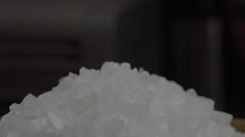 Macro close up of coarse sea salt crystals forming textured white pile on dark Stock Footage 341431132