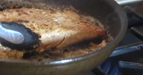 Macro Close Up of Cooking Salmon in Garlic and Butter in Cast Iron Pan Stock Footage 262095872