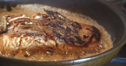 Macro Close Up of Cooking Salmon in Garlic and Butter in Cast Iron Pan Stock Footage 262096168