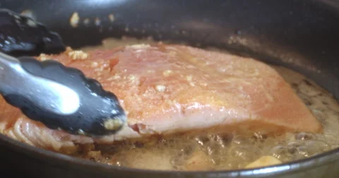 Macro Close Up of Cooking Salmon in Garlic and Butter in Cast Iron Pan Stock Footage 262097832