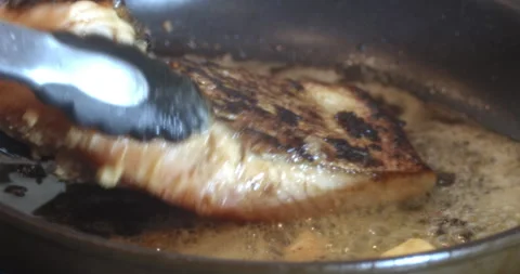 Macro Close Up of Cooking Salmon in Garlic and Butter in Cast Iron Pan Stock Footage 262098099