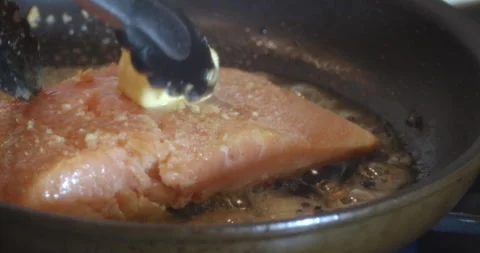 Macro Close Up of Cooking Salmon in Garlic and Butter in Cast Iron Pan Stock Footage 262101372