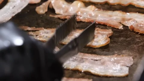 Macro Close-up of Crispy Bacon Strips Sizzling on a Professional Restaurant Gril Stock Footage 331633140