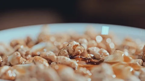 Macro Close-Up of Crispy Puffed Grain Cereal in Creamy Yogurt Vídeos de archivo 344687339