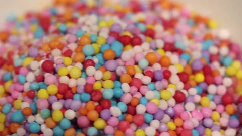 Macro close up dolly past colored candy sprinkles in a white bowl Stock Footage 156454974