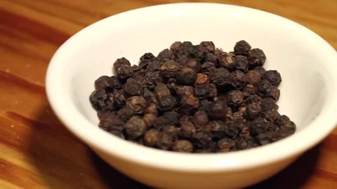 Macro close up dolly past white bowl of black peppercorns Stock Footage 156456028