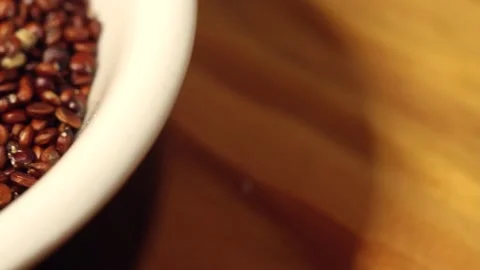 Macro close up dolly past white bowl of red quinoa seeds Stock Footage 156460641