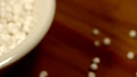 Macro close up dolly past white bowl of dry sago pearls Stock Footage 156460982