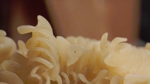 Macro Close Up of Dry Spiral Pasta Showing Texture and Curled Noodle Detail Stock Footage 339763682