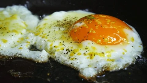 Macro close-up eggs fried on a griddle in slow motion Stock Footage 102282349