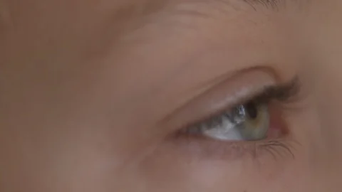 Macro Close-up eye blinking. Young girl is opening and closing her beautiful Stock Footage 94050110