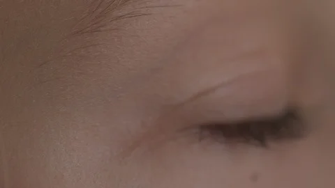 Macro Close-up eye blinking. Young girl is opening and closing her beautiful Stock Footage 94050127