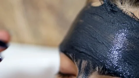 Macro close-up girl puts on the face black cleansing cream mask. Skin care Stock Footage 103722476