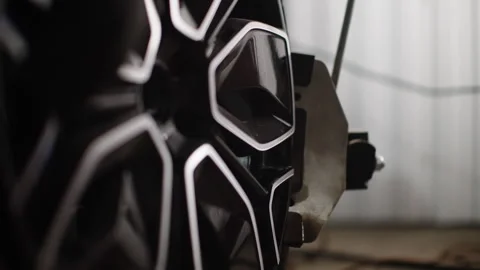 Macro close-up of a glossy black alloy wheel with intricate geometric spokes Video stock 333839358