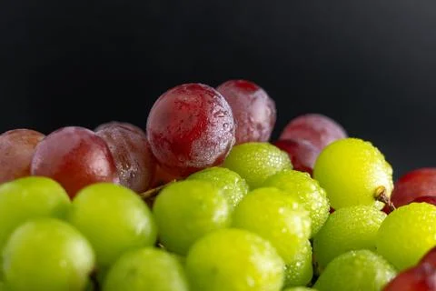 Macro Close-Up of Green and Red Grapes with Water Drops on White Plate Foto stock