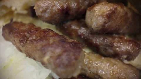 Macro close-up of grilled cevapi as the camera moves right, emphasizing tex.. Video stock 322570274