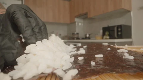 Macro Close-Up of a Hand in a Black Glove Distributing Sushi Rice on Nori, While Vídeo Stock 304998401