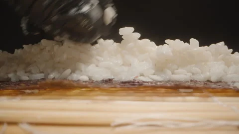Macro Close-Up of a Hand in a Black Glove Evenly Distributing Sushi Rice Over a Vídeo Stock 305021570