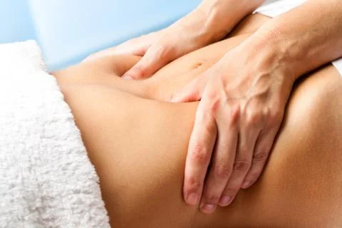 Macro close up of hands massaging female abdomen. Stock Photos