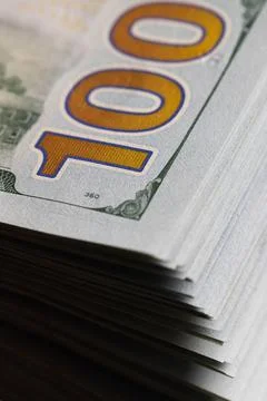 Macro close up of hundred US dollar bills stack showing large gold number 100 Stock Photos