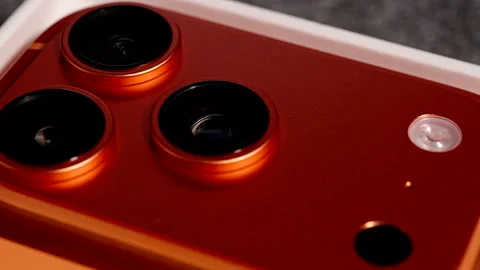 Macro Close-Up of iPhone 17 Pro in Cosmic Orange Color with Triple Camera Lenses Stock Footage 318056663