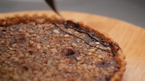 Macro Close-up of Liquid Chocolate Drizzling over a Freshly Baked Homemade Nut T Stock Footage 337751512